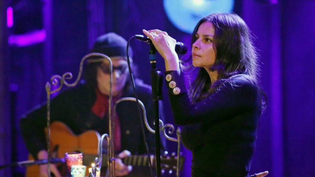 Hope Sandoval performing on stage, representing her career as a musician and how she earns money.