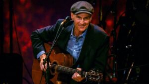 James Taylor performing live on stage with guitar