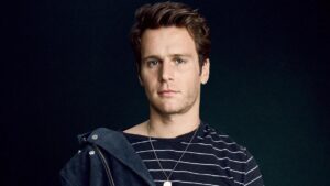 Jonathan Groff posing during a professional photo shoot, wearing a stylish outfit