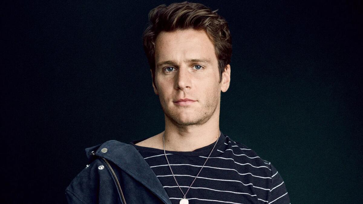 Jonathan Groff posing during a professional photo shoot, wearing a stylish outfit