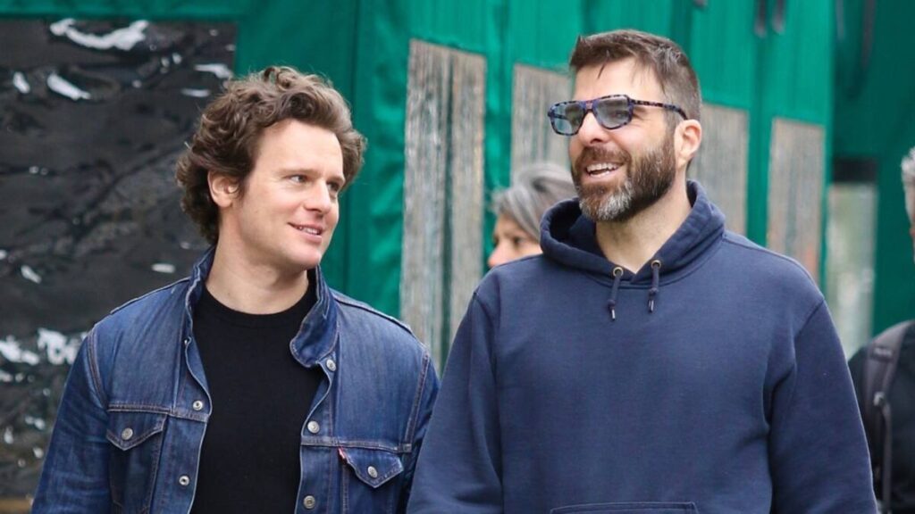 Jonathan Groff and Zachary Quinto walking together on the street before their split, both looking casual and relaxed.