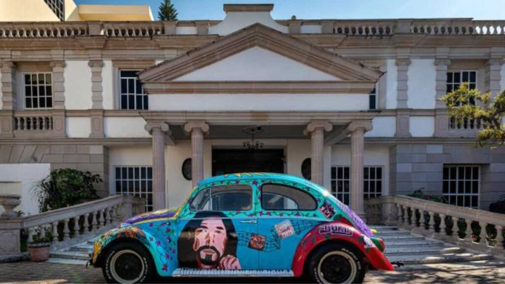 Marco Antonio Solís standing next to his vintage luxury car, showcasing his classic automotive collection and wealthy lifestyle in 2025.