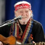 Willie Nelson performing live on stage with his guitar, Trigger