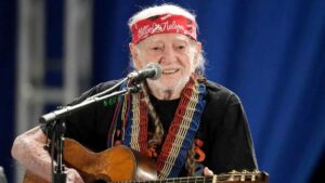 Willie Nelson performing live on stage with his guitar, Trigger