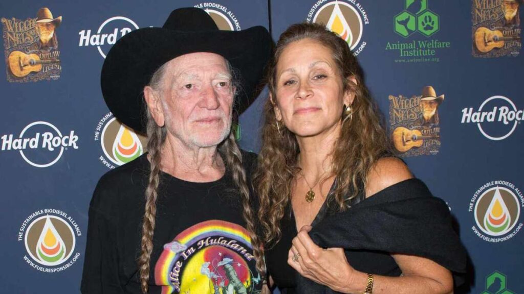 Willie Nelson and his wife Annie D’Angelo smiling together at a public event.