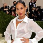 Alicia Keys on the red carpet at the 2025 GRAMMY Awards, posing for media photographers in a shimmering black gown.