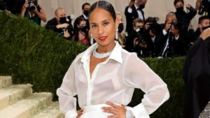 Alicia Keys on the red carpet at the 2025 GRAMMY Awards, posing for media photographers in a shimmering black gown.