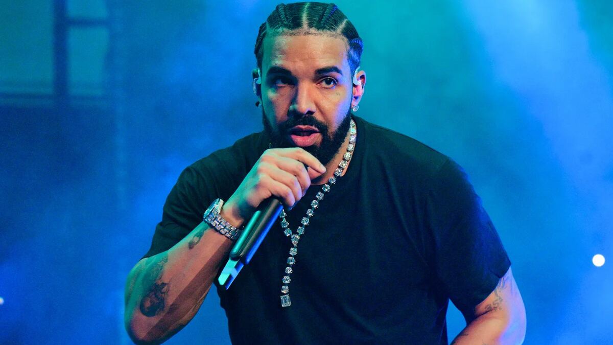 Drake performing live on stage wearing a black t-shirt during a concert.