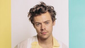 Harry Styles in a studio photo shoot, showcasing his signature eclectic style and bold fashion choices.