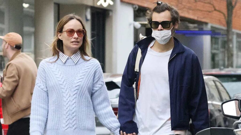 Harry Styles and Olivia Wilde walking together on a city street before their 2022 split, casually dressed and holding hands.