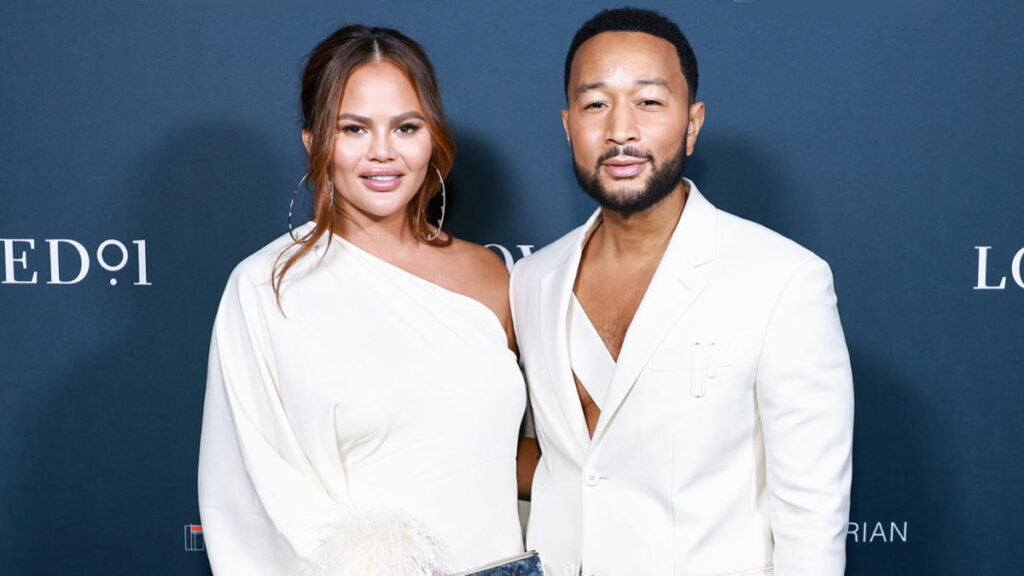 John Legend and Chrissy Teigen posing together at a event