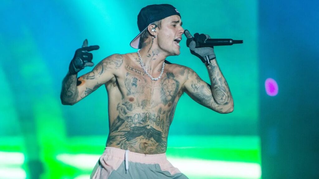 Justin Bieber performing on stage during a world tour, showcasing his evolution from teen pop star to global music icon.