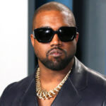 Close-up of Kanye West at a fashion event, looking serious and stylish
