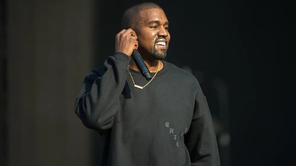 Kanye West performing live on stage during a major concert event, showcasing his music career