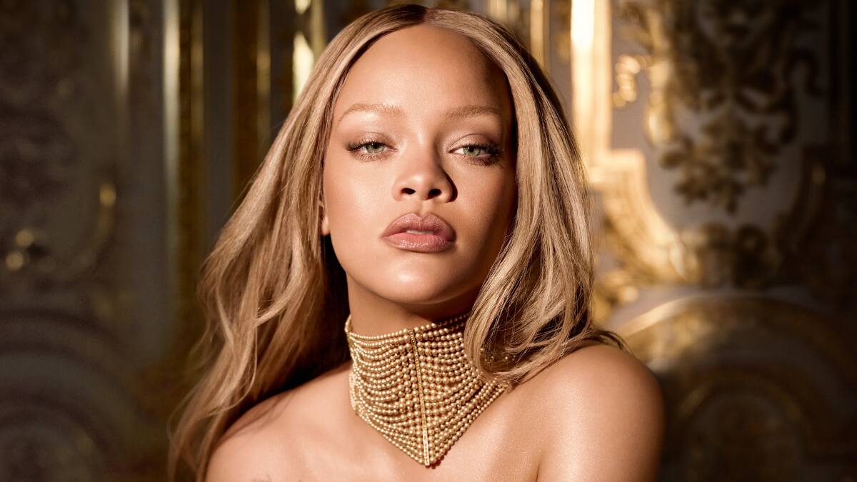 Rihanna smiling in a promotional shoot for Fenty Beauty