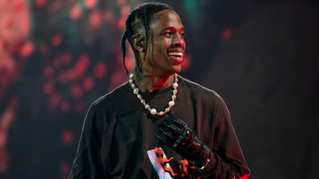Travis Scott performing on stage during his Astroworld Tour, surrounded by pyrotechnics and a cheering crowd