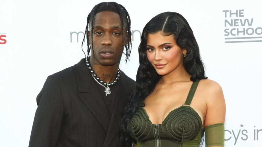 Travis Scott and Kylie Jenner at the 2022 Met Gala, wearing coordinated beige and black outfits on the red carpet.