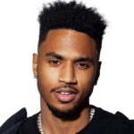 Trey Songz striking a pose in a studio with moody lighting and designer outfit
