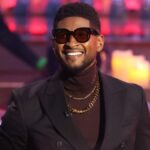 Usher performing on stage during Las Vegas residency with spotlight