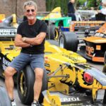 Eddie Jordan standing beside a Jordan Grand Prix Formula One car during a motorsport event