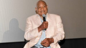 George Foreman smiling at a public event in a suit