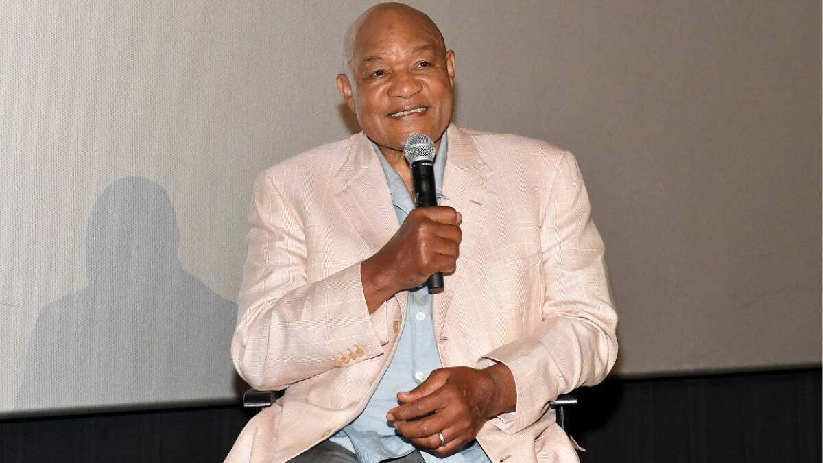 George Foreman smiling at a public event in a suit