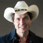 Kimbal Musk smiling in a professional headshot wearing his signature cowboy hat.