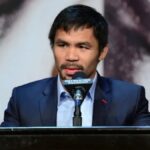 Manny Pacquiao smiling in a suit during a press conference in Manila.