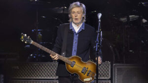 Paul McCartney performing live on stage with guitar during a concert