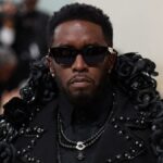 Sean Combs at a public event, wearing a tailored suit and sunglasses
