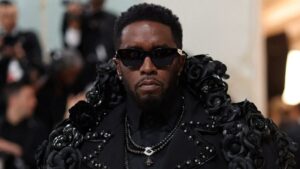 Sean Combs at a public event, wearing a tailored suit and sunglasses