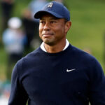 Tiger Woods smiling in a golf cap at a PGA event