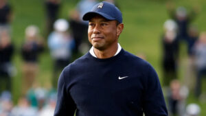 Tiger Woods smiling in a golf cap at a PGA event