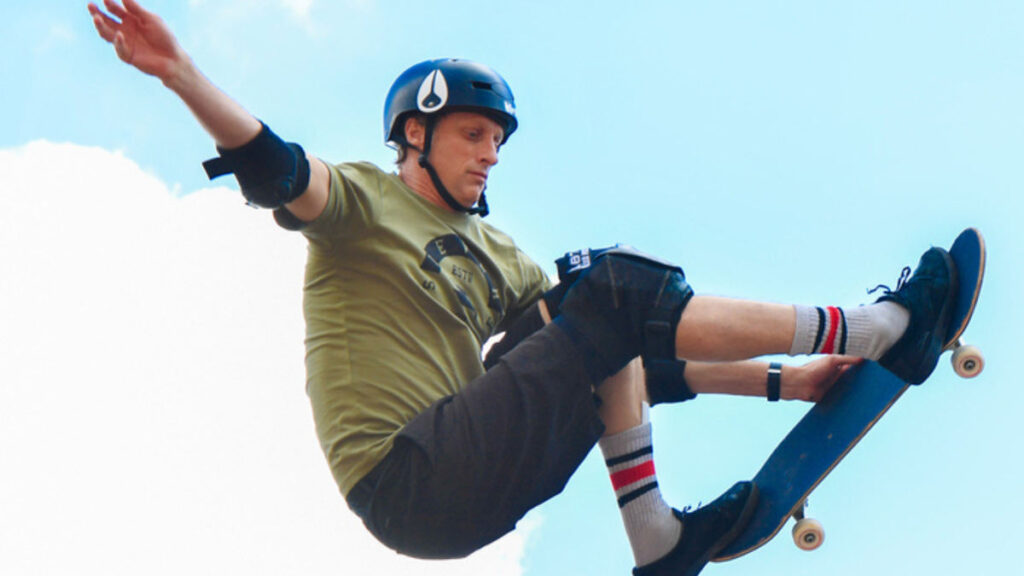 Tony Hawk executing a mid-air 900 trick at a skateboarding competition