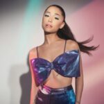 Ariana Grande posing in a REM Beauty photo shoot, wearing futuristic makeup and styled in soft-glam, space-inspired fashion to reflect the brand’s aesthetic.