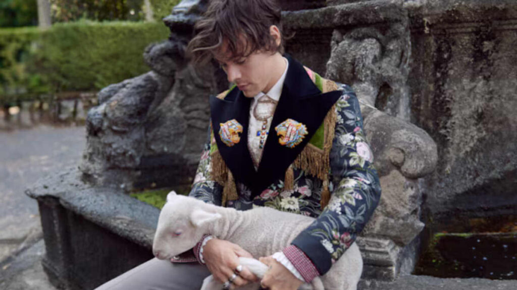 Harry Styles holding a model ship, symbolizing creative direction and personal brand identity beyond Gucci collaborations